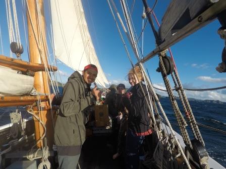 Trainees hoisting sail with thumbs up